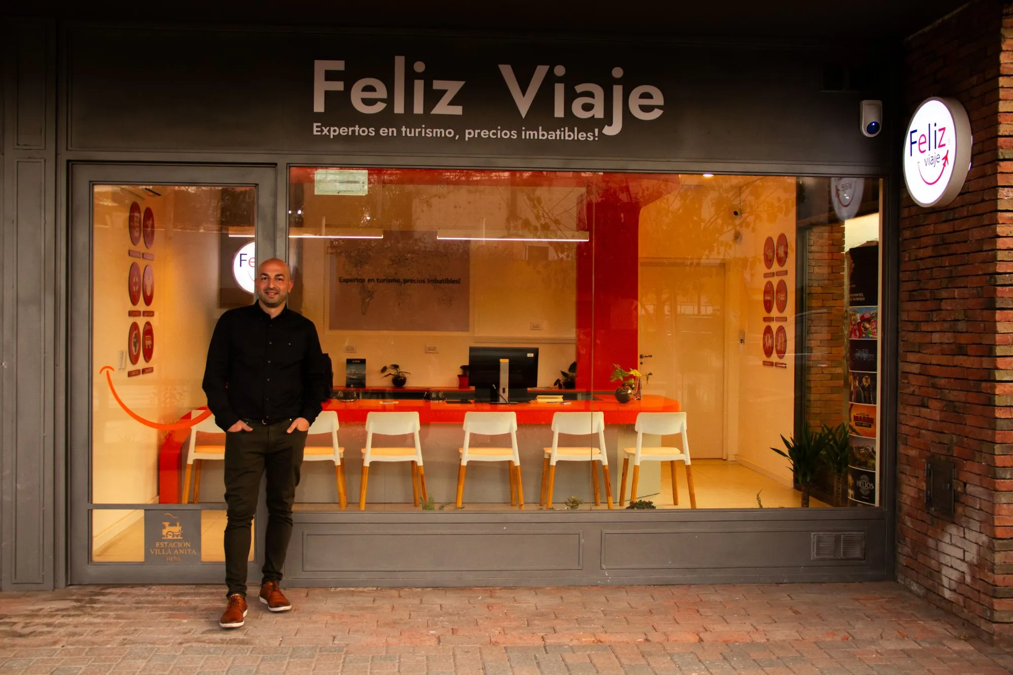 Fachada de un local Feliz Viaje con su socio en la puerta