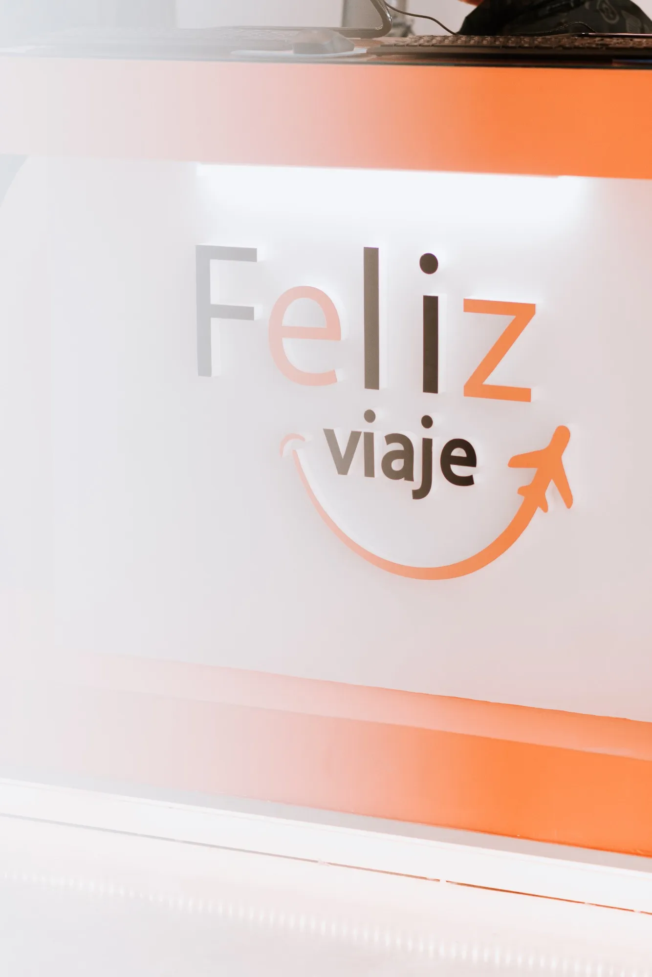 Logo de Feliz Viaje en el mostrador de un local diseñado por la empresa